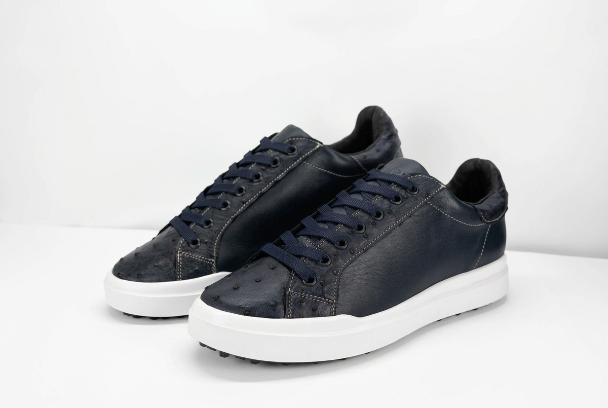 Tenis de tono oscuro con suela blanca, fondo blanco e iluminación suave