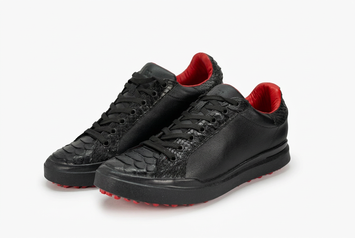 Tenis negros con detalles rojos sobre fondo blanco